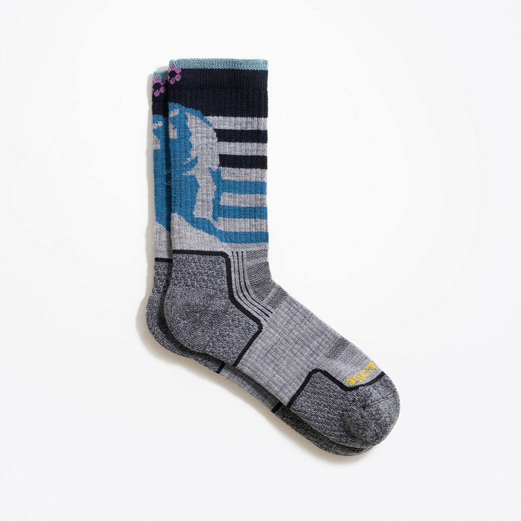 Profile view - multicolor (grey, blue haze, twilight blue and black) women's hiking sock featuring a black bear on the back and stripes on the front with the ToughCutie logo on the toe