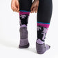 Woman putting on the lavender version of the sasha the fierce bear hiking sock showing the bears on the back of the leg