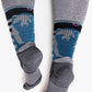 Woman with wider calf wearing the grey version of the sasha the fierce bear hiking sock showing the bears on the back of the leg