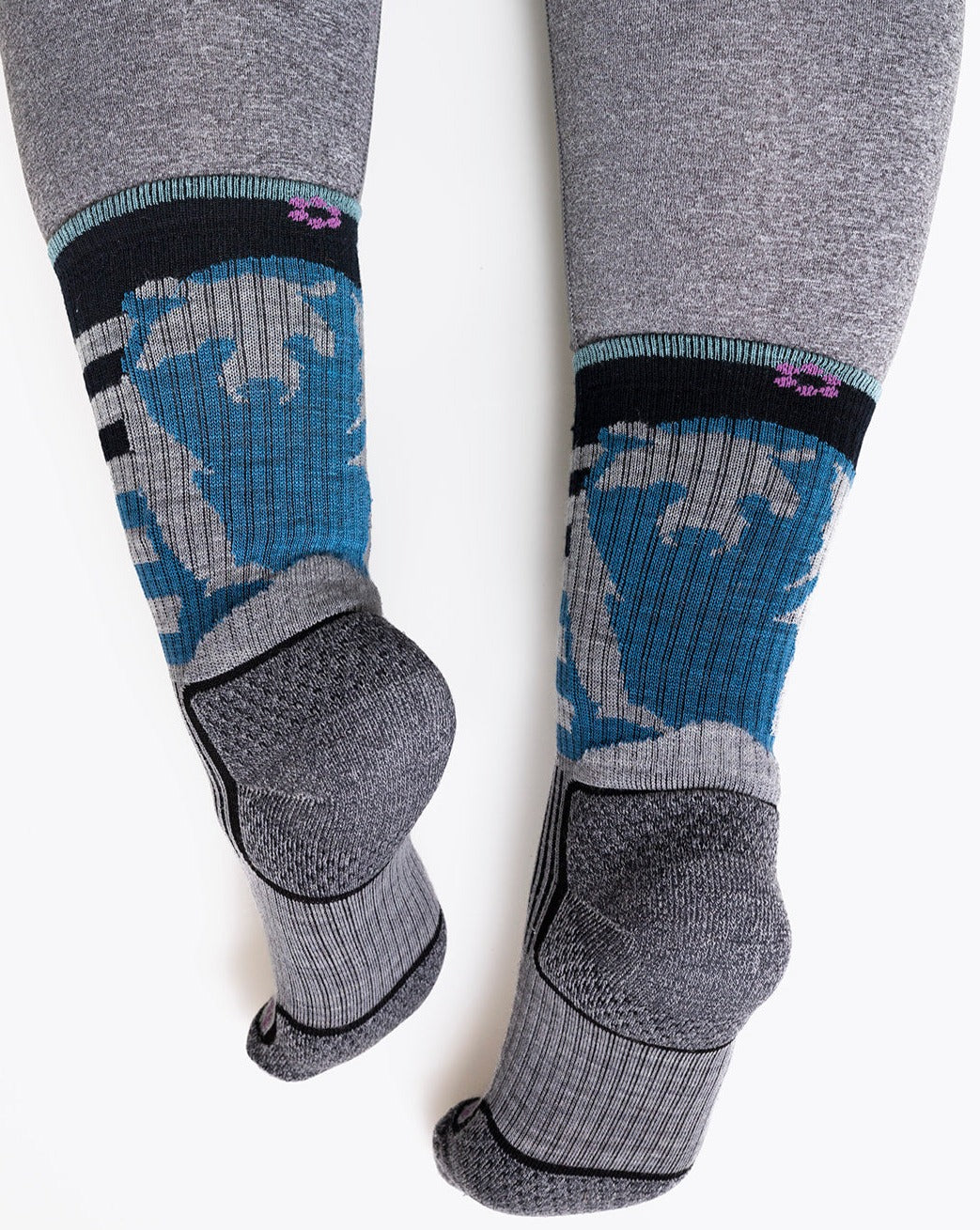 Woman with wider calf wearing the grey version of the sasha the fierce bear hiking sock showing the bears on the back of the leg