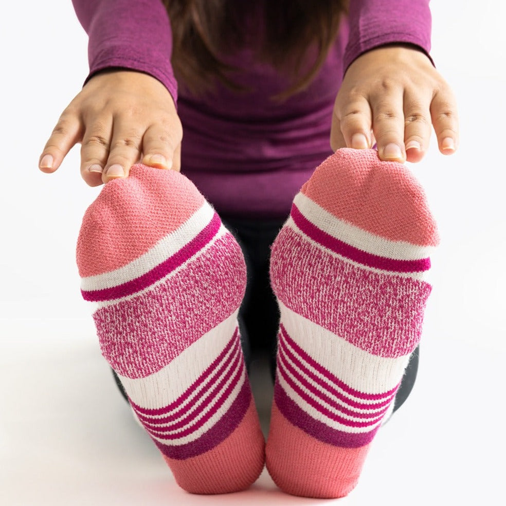 Woman stretching wearing the white boysenberry ToughCutie running sock